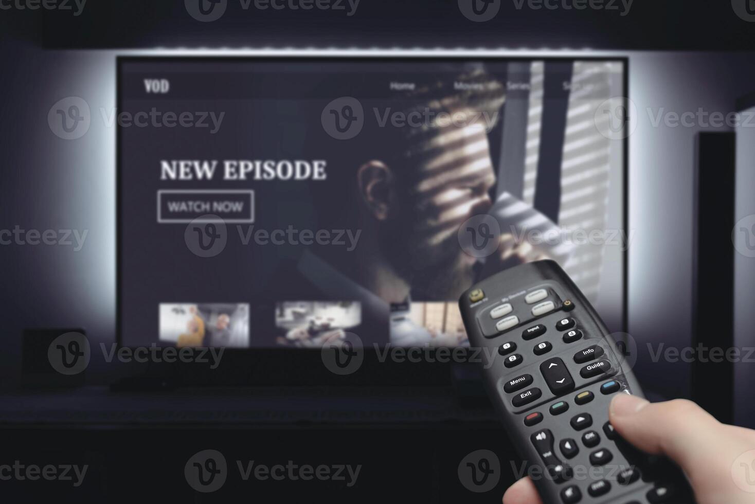 A person holding a remote control in front of a television screen photo