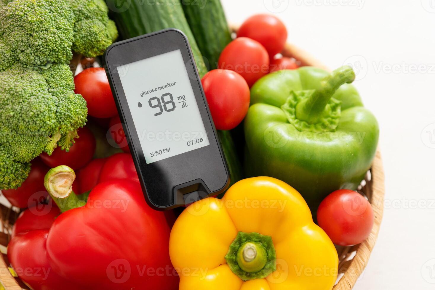 A basket of vegetables and a digital blood sugar monitor photo