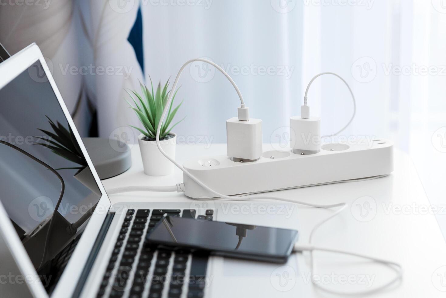 A laptop and charger are connected to a power strip photo