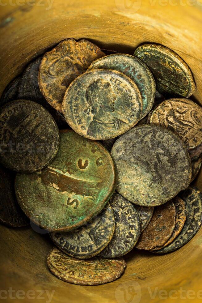 Ancient Roman coins collection in a container, close-up view. photo
