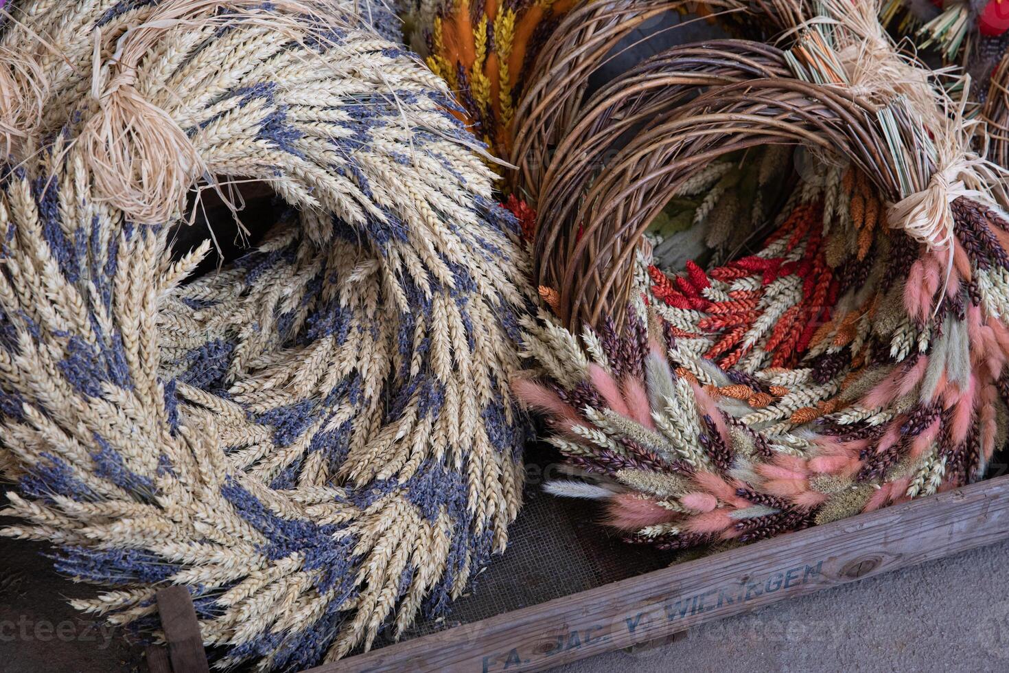 Brightly crafted spring wreaths featuring spikelets, lavender flowers and festive Easter decorations are displayed at a local market. These unique creations add charm to Easter celebrations. photo
