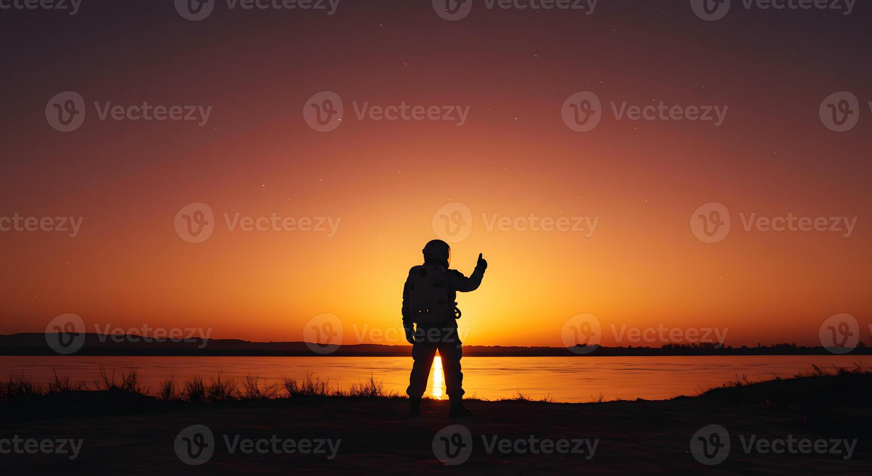 A silhouette of a man standing on a beach at sunset photo