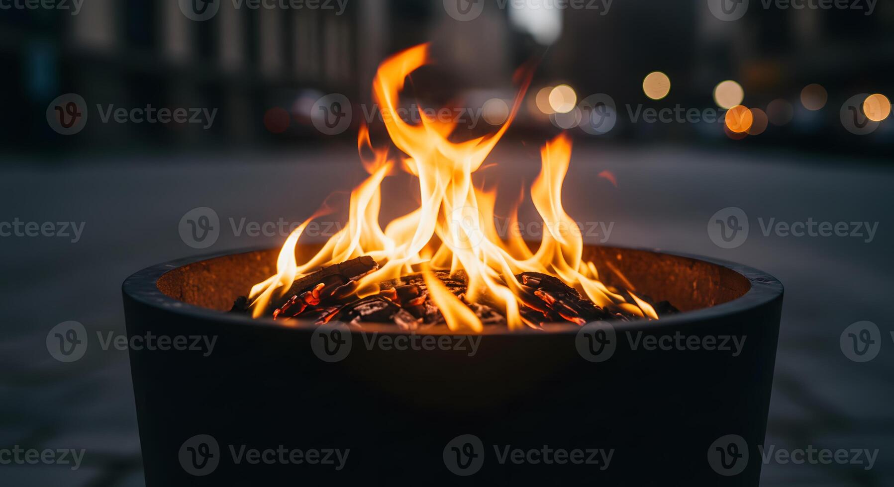 A fire pit on the street with a city in the background photo