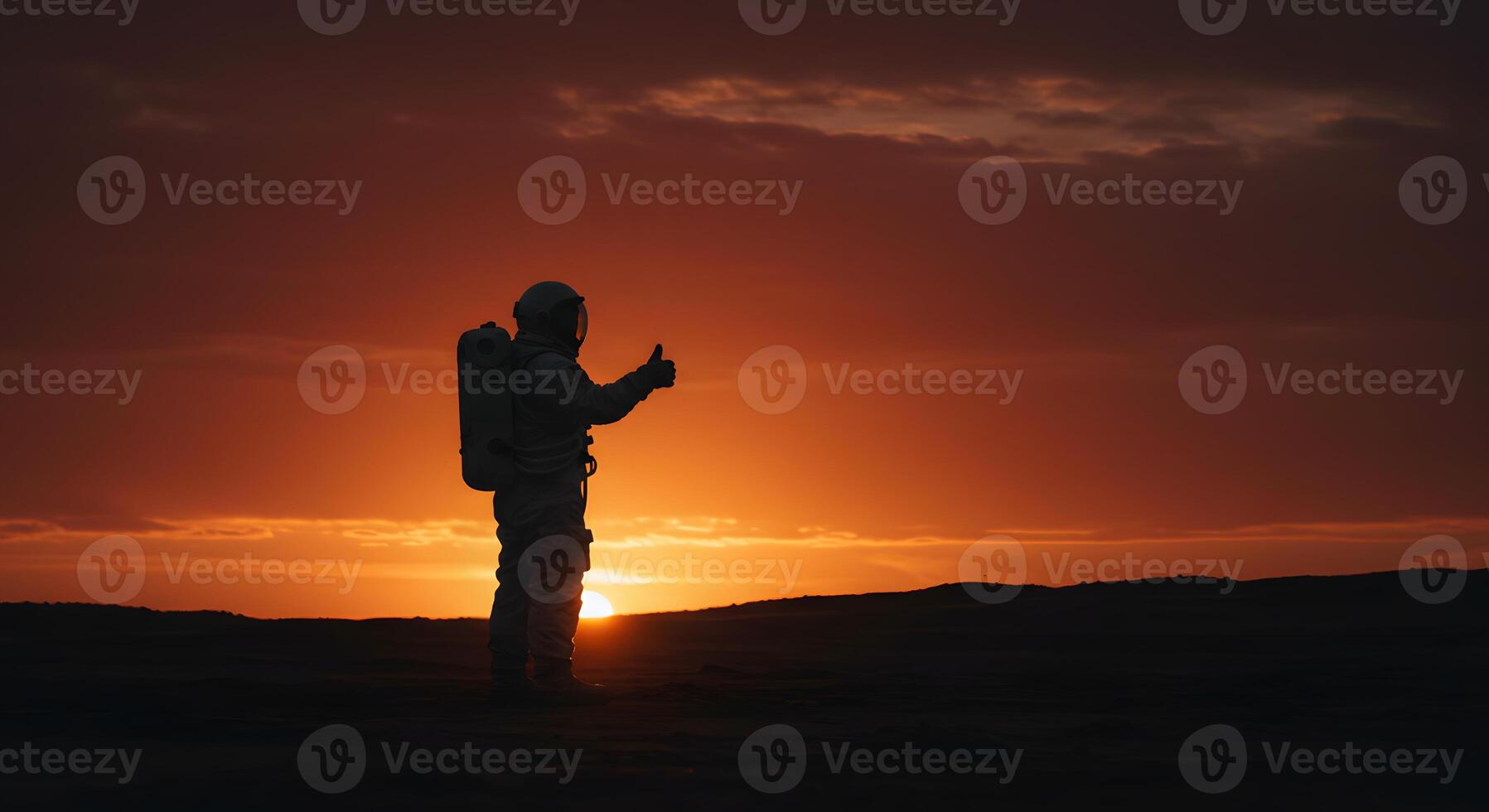 A man in a space suit standing on a hill at sunset photo