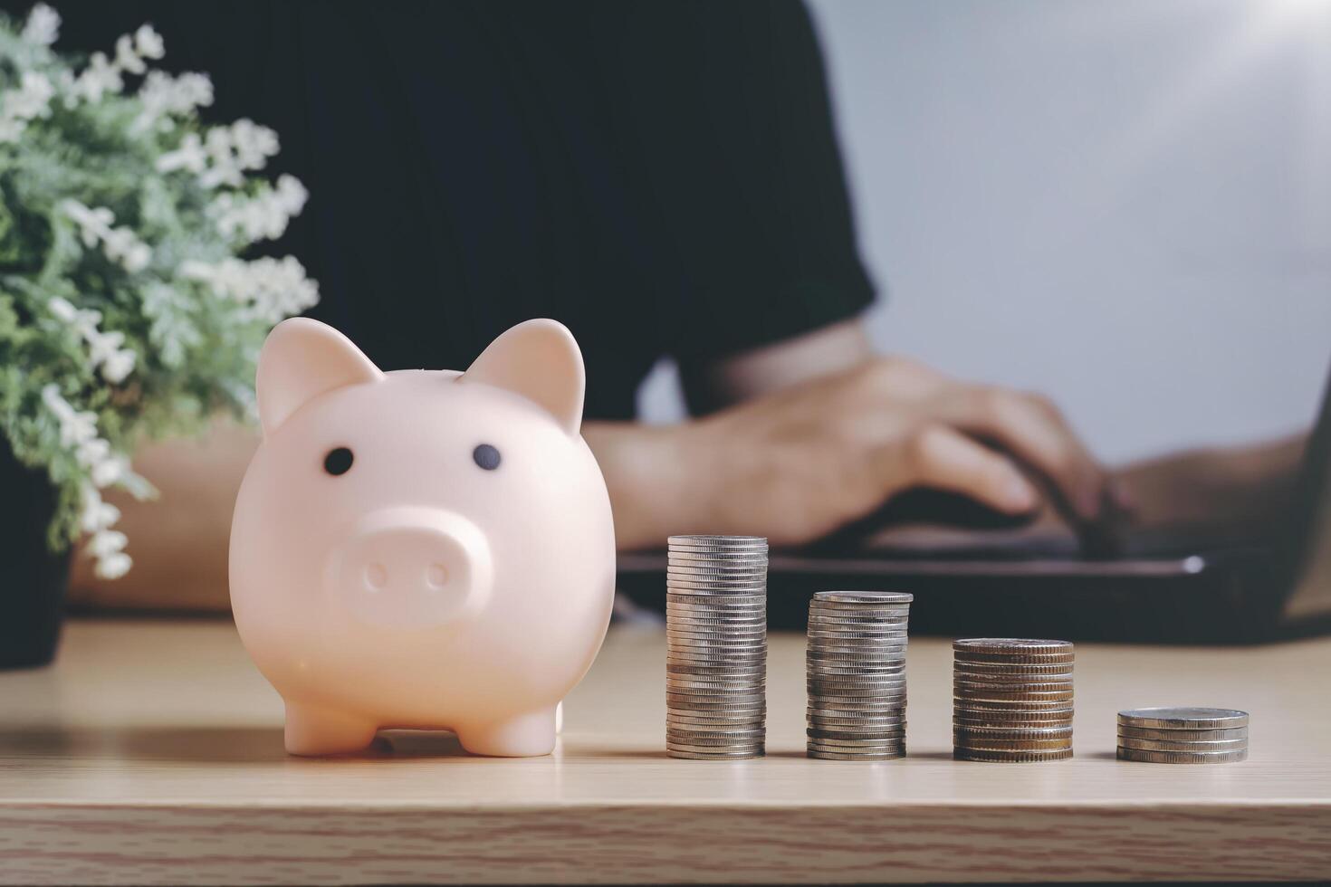 Saving money wealth and financial concept. Asian men working at home during the crisis are calculate family income and expenses, along with pension coins and piggy banks on wooden floors. photo