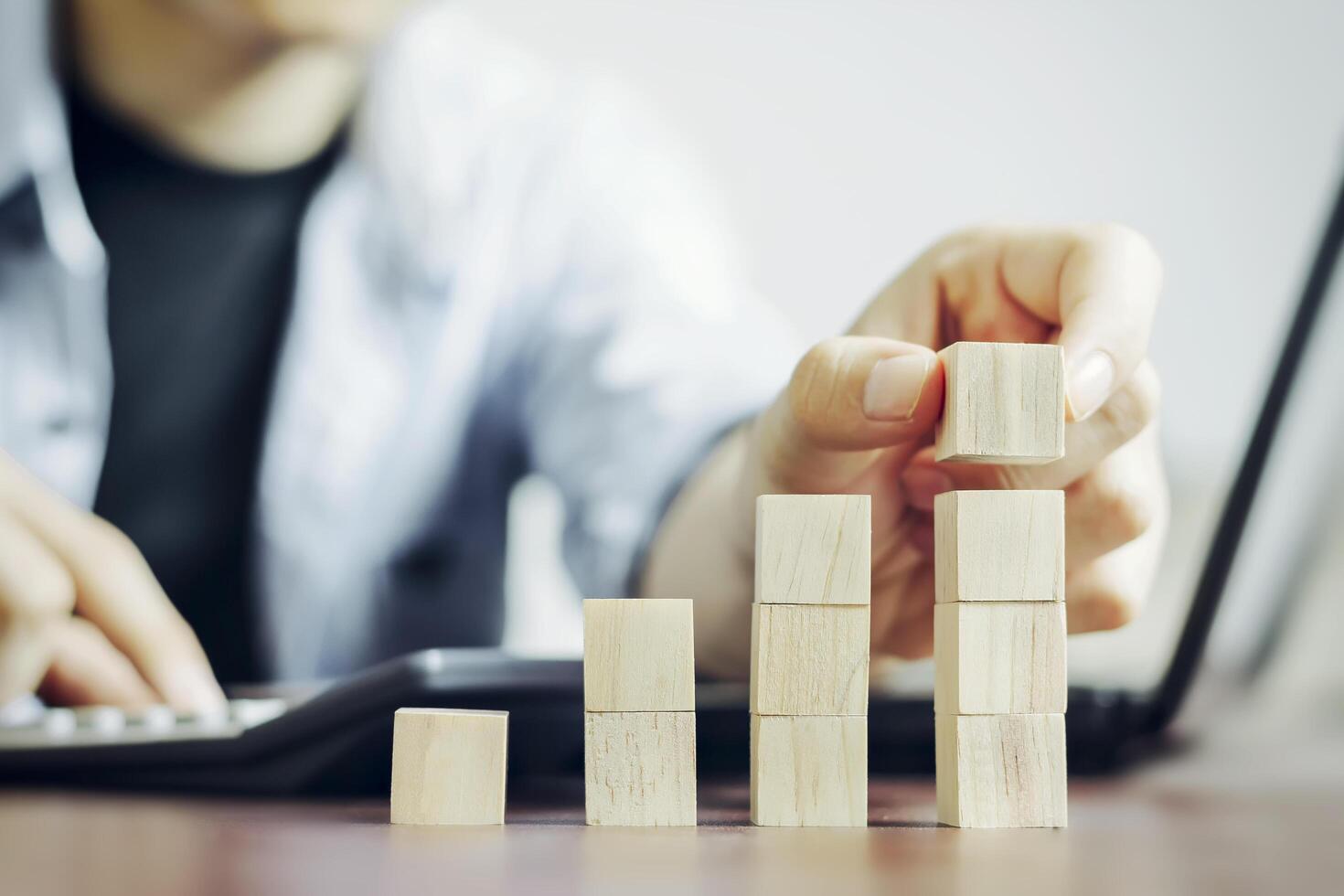 Businessmen use their fingers to touch a wooden bar that shows business graphs, forecasts, and calculates plans to increase business growth and business in the direction of growth and success. photo