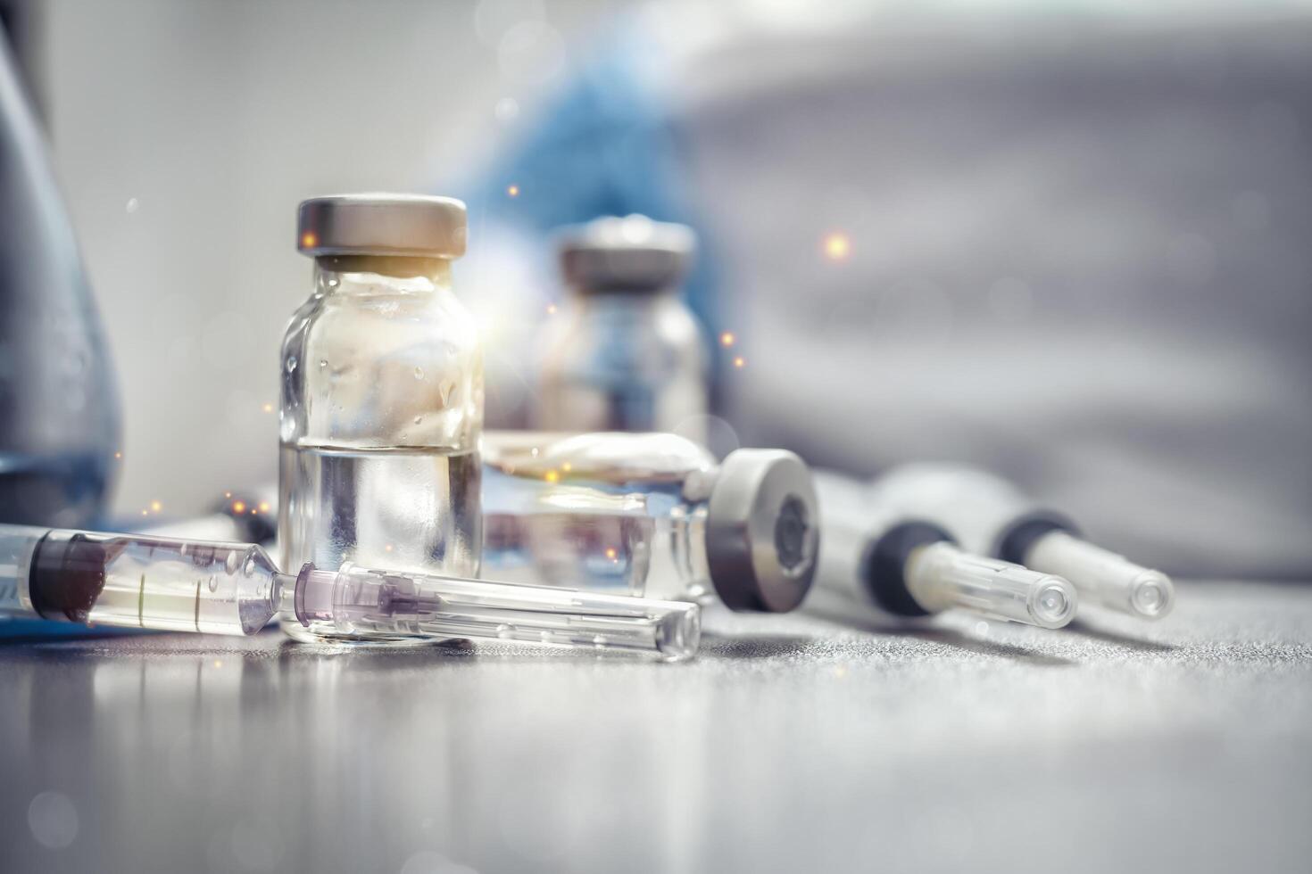 Vaccines bottle and Syringes Used for prevention, immunity and treatment from covid-19 infection or coronavirus. Concepts of disease prevention. Focus on syringes and vials, blurred background. photo