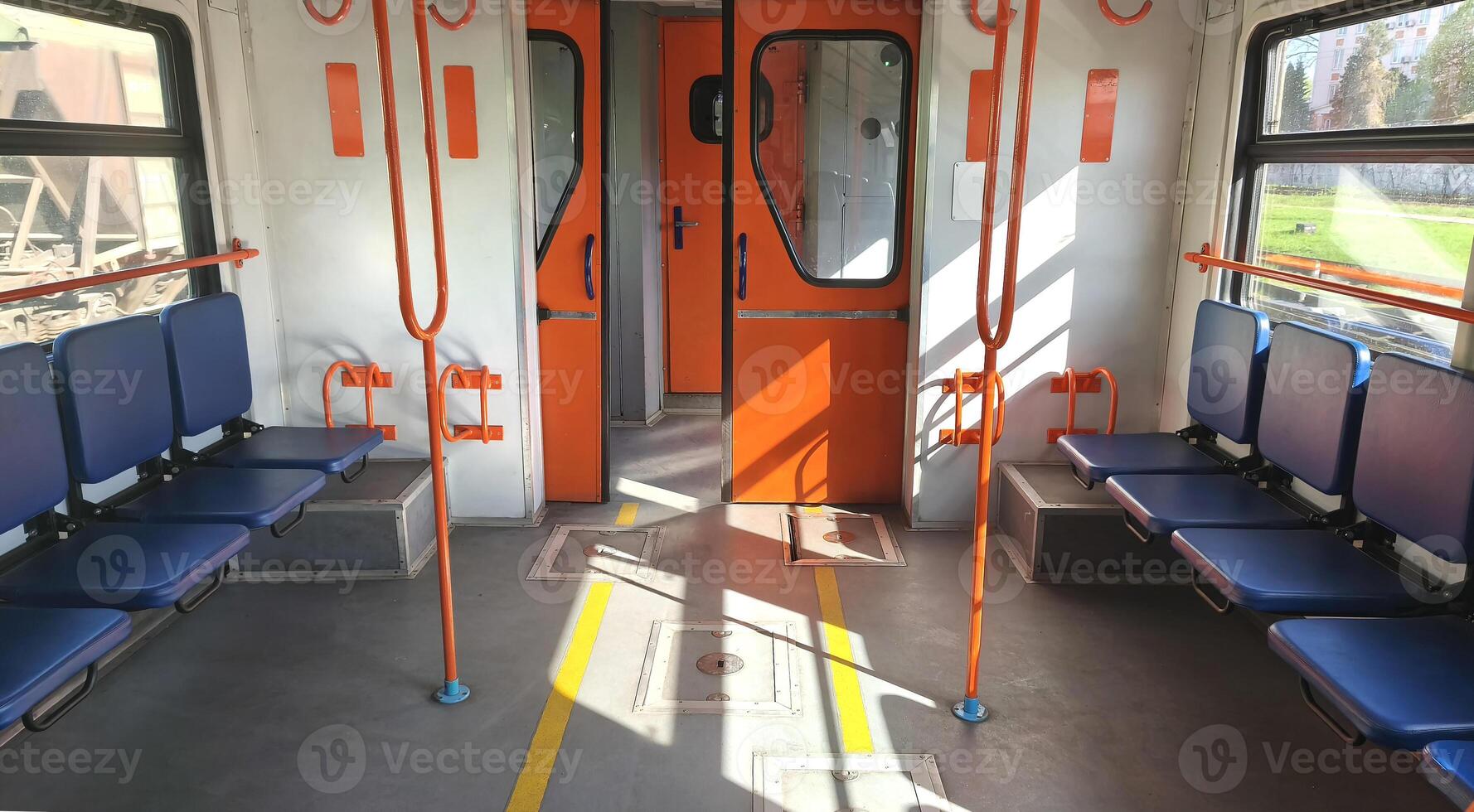 Empty carriage with blue seats and orange handrails of a city or intercity electric train. City transport, carriage interior photo