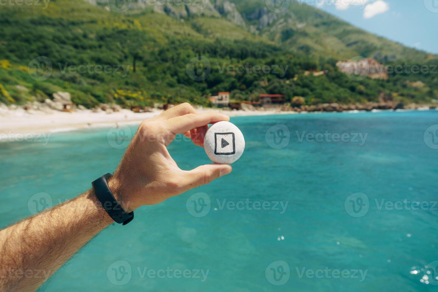 Holding a Play Button Icon Over a Beautiful Ocean View photo