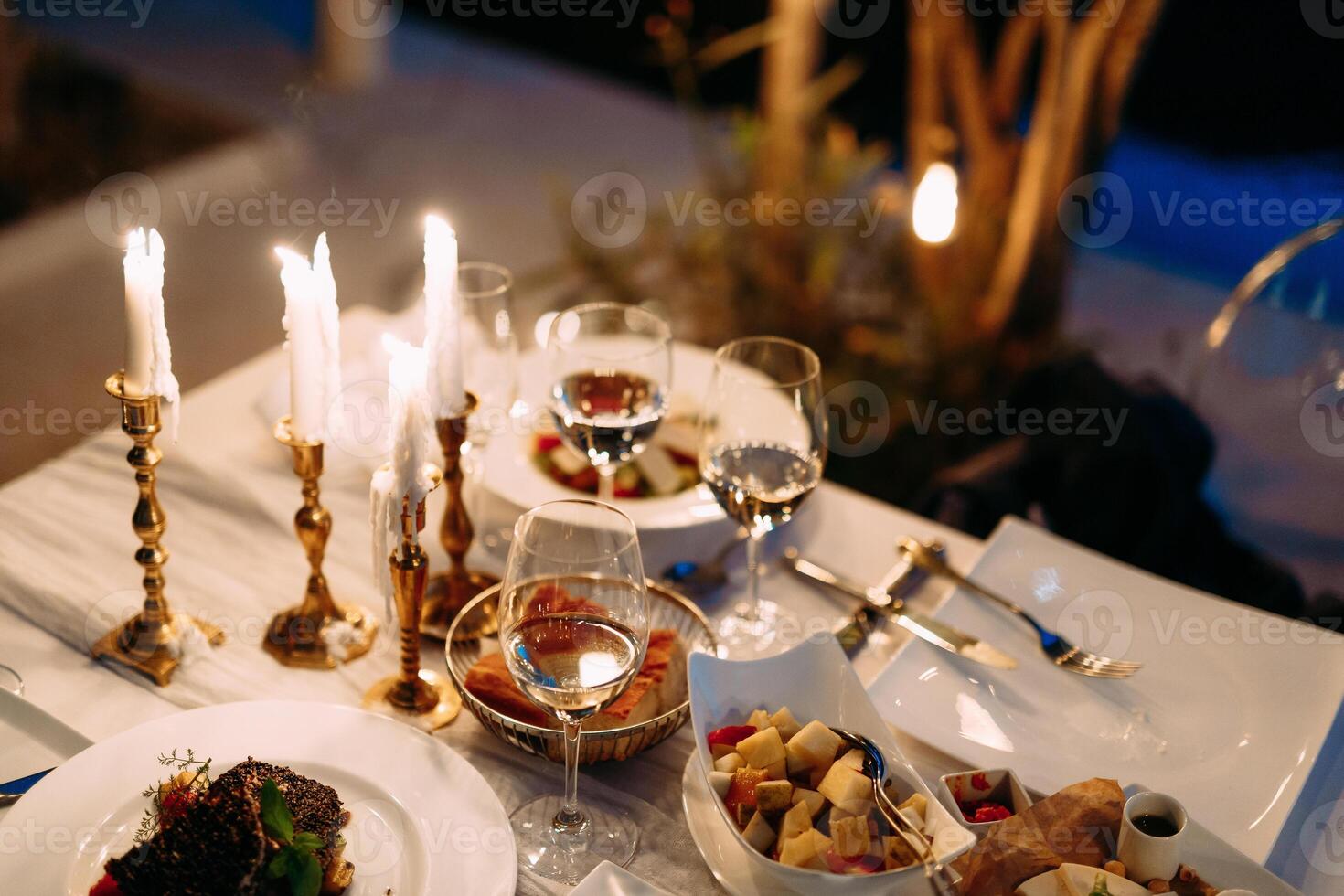 Elegant Dinner Table Setting with Candles and Gourmet Dishes photo