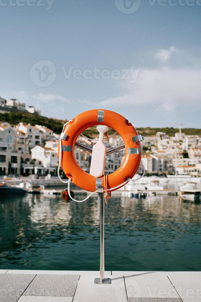 Lifebuoy on a stand with a latch stands on the shore of Lustica Bay. Montenegro photo