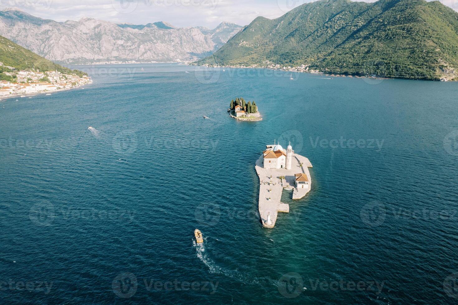 Motor boat sails past the island of Gospa od Skrpjela to the island of St. George. Montenegro. Drone photo