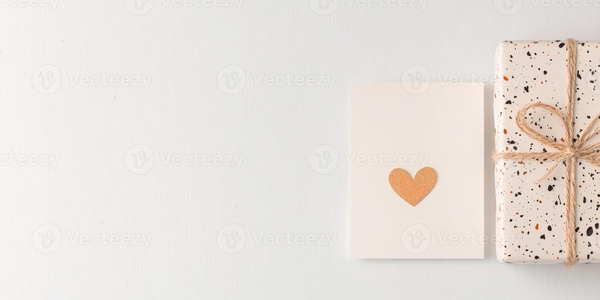 Gift box with speckled wrapping paper and heart card on white background photo