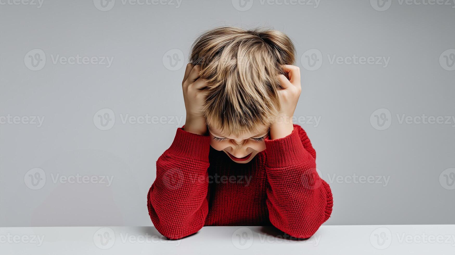 Distressed child holding head in visible frustration and emotional overload. Concept of trichotillomania, childhood stress, mental health, and mindful parenting. photo