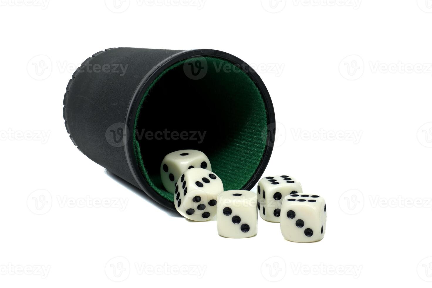 Tipped black dice cup spilling out random assortment of white dice set against a white backdrop photo