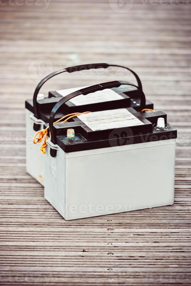Car batteries sitting on wooden floorboards, industrial concept photo