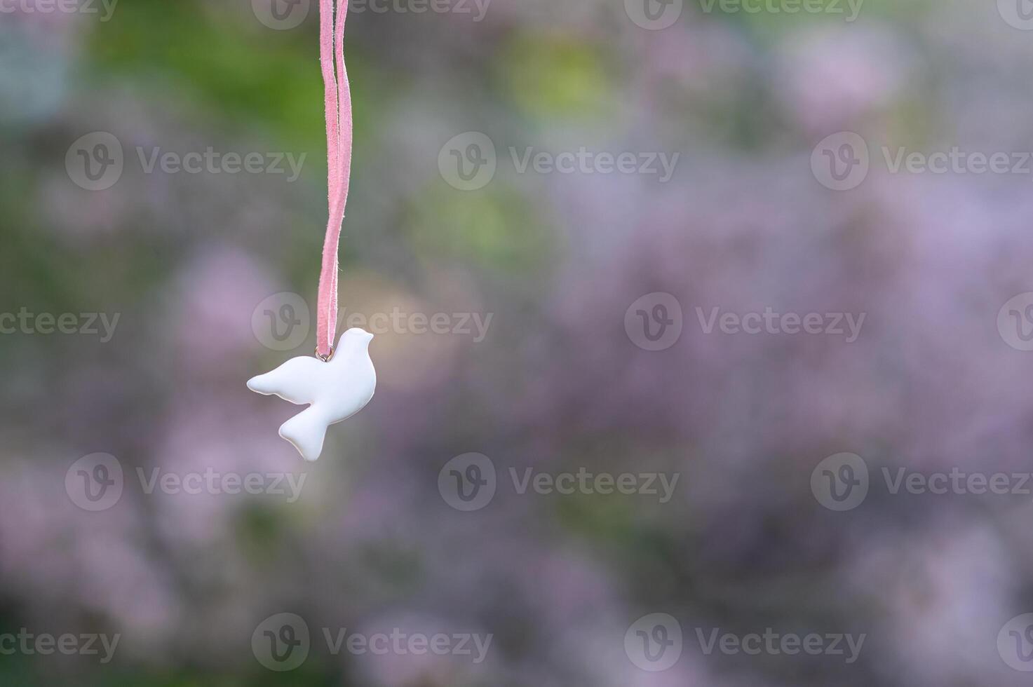 white bird hanging from a pink ribbon photo