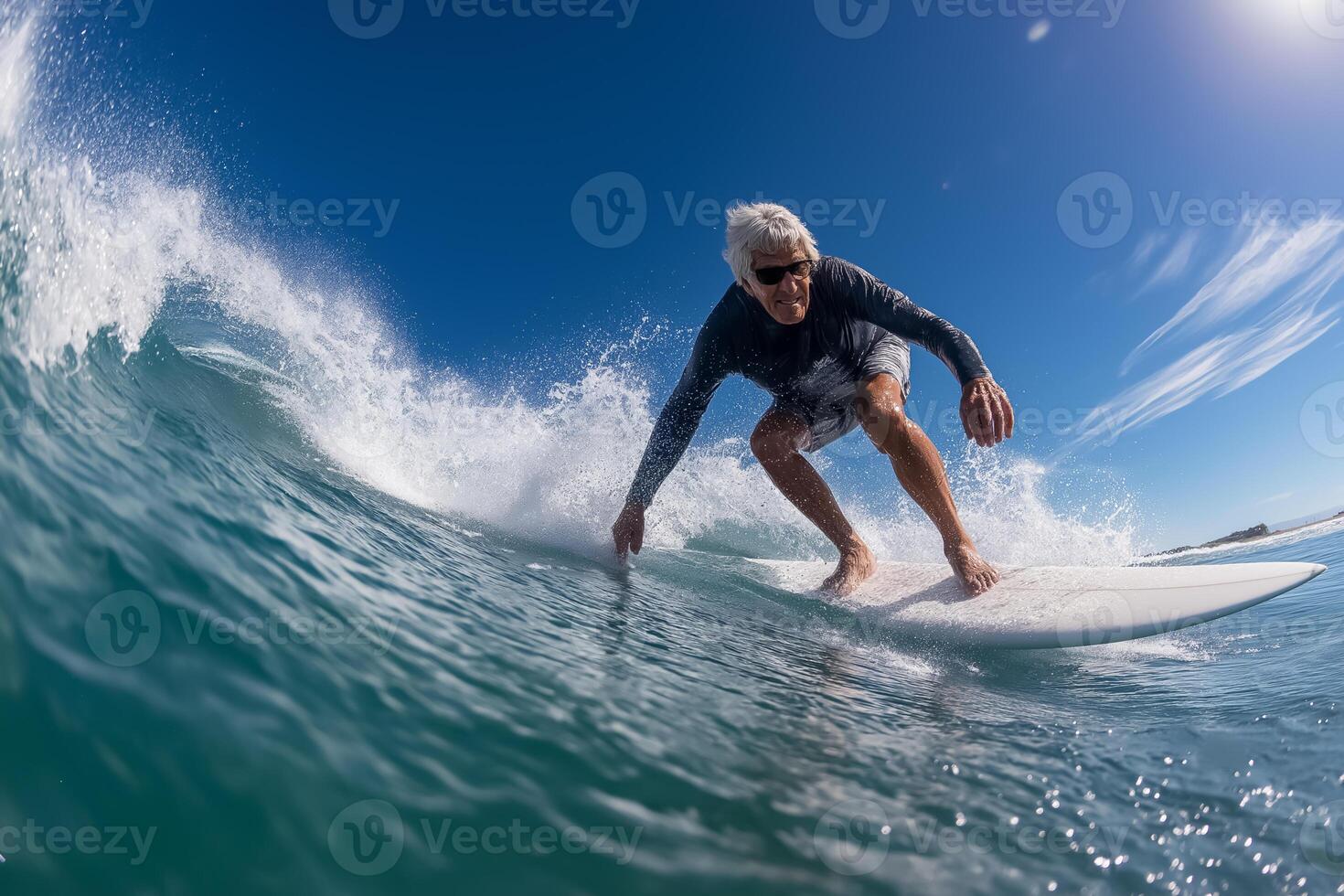 An older man riding a wave on a surfboard photo