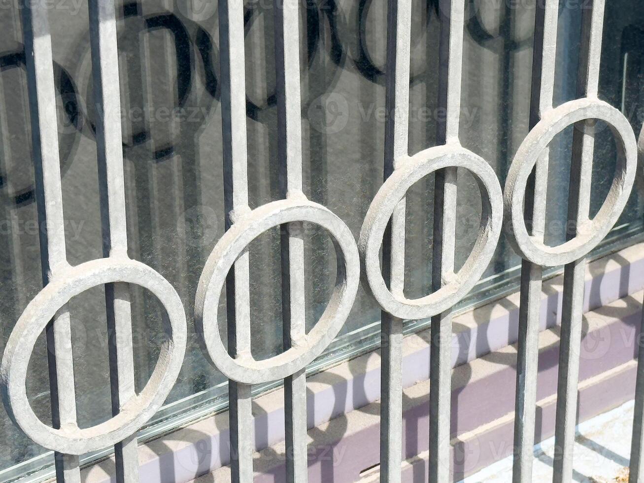 Abstract decorative metal railing with circle pattern in sunlight photo