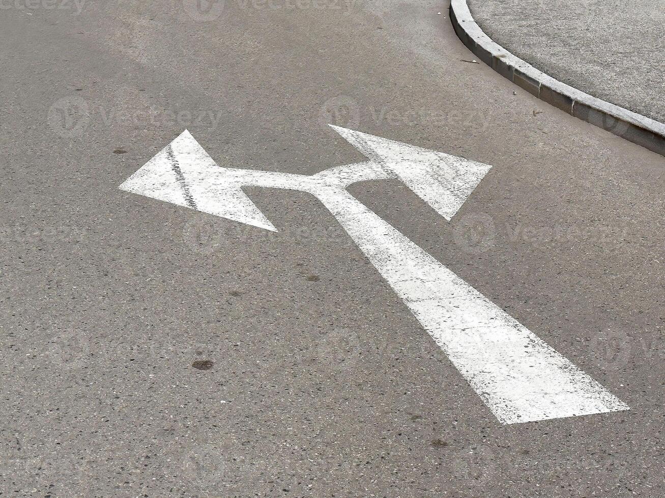 Directional arrows on urban asphalt road surface with curve photo