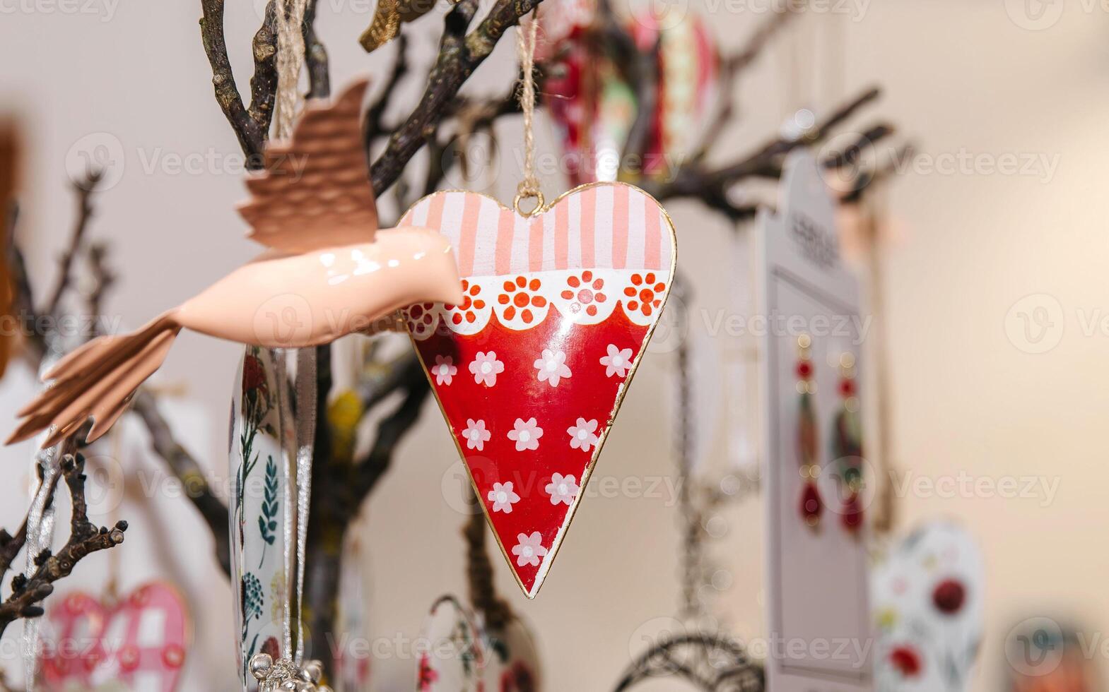 Colorful heart-shaped decorations hanging on tree branches for holiday celebration photo