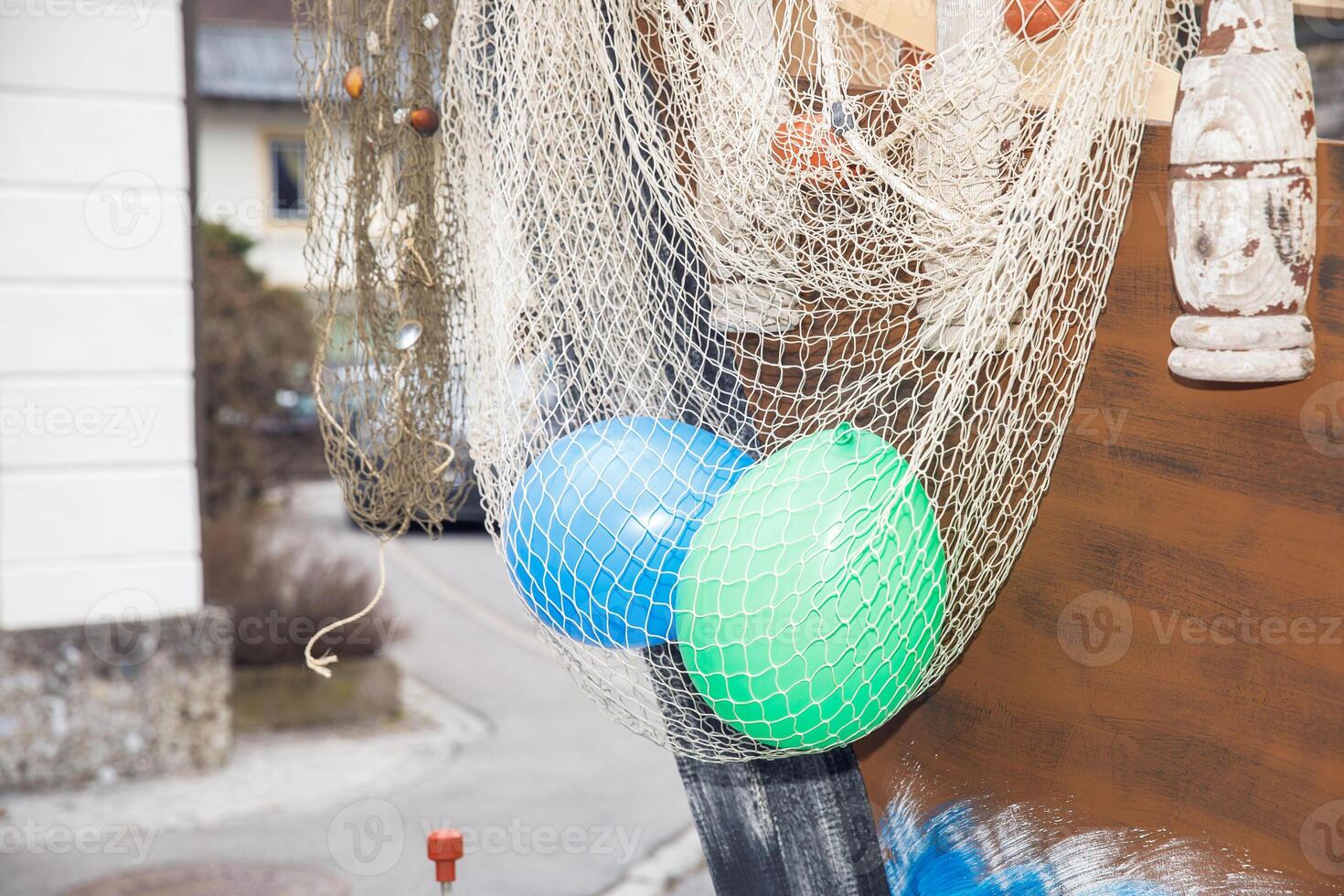 Fishing nets with colorful balloons on rustic wooden boat exterior photo