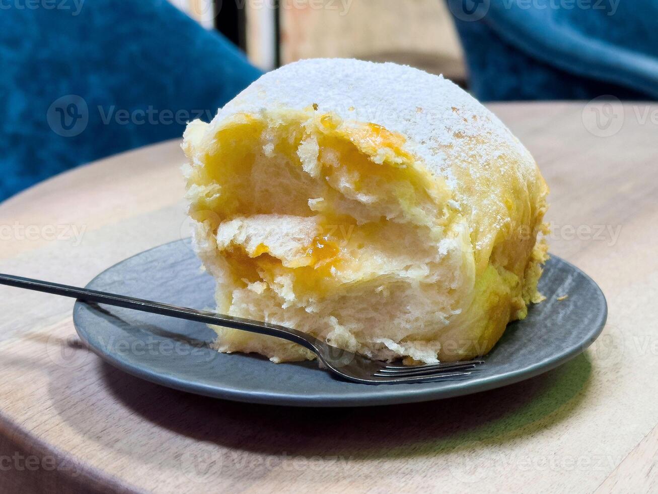 Soft brioche roll with sweet cream filling on plate photo