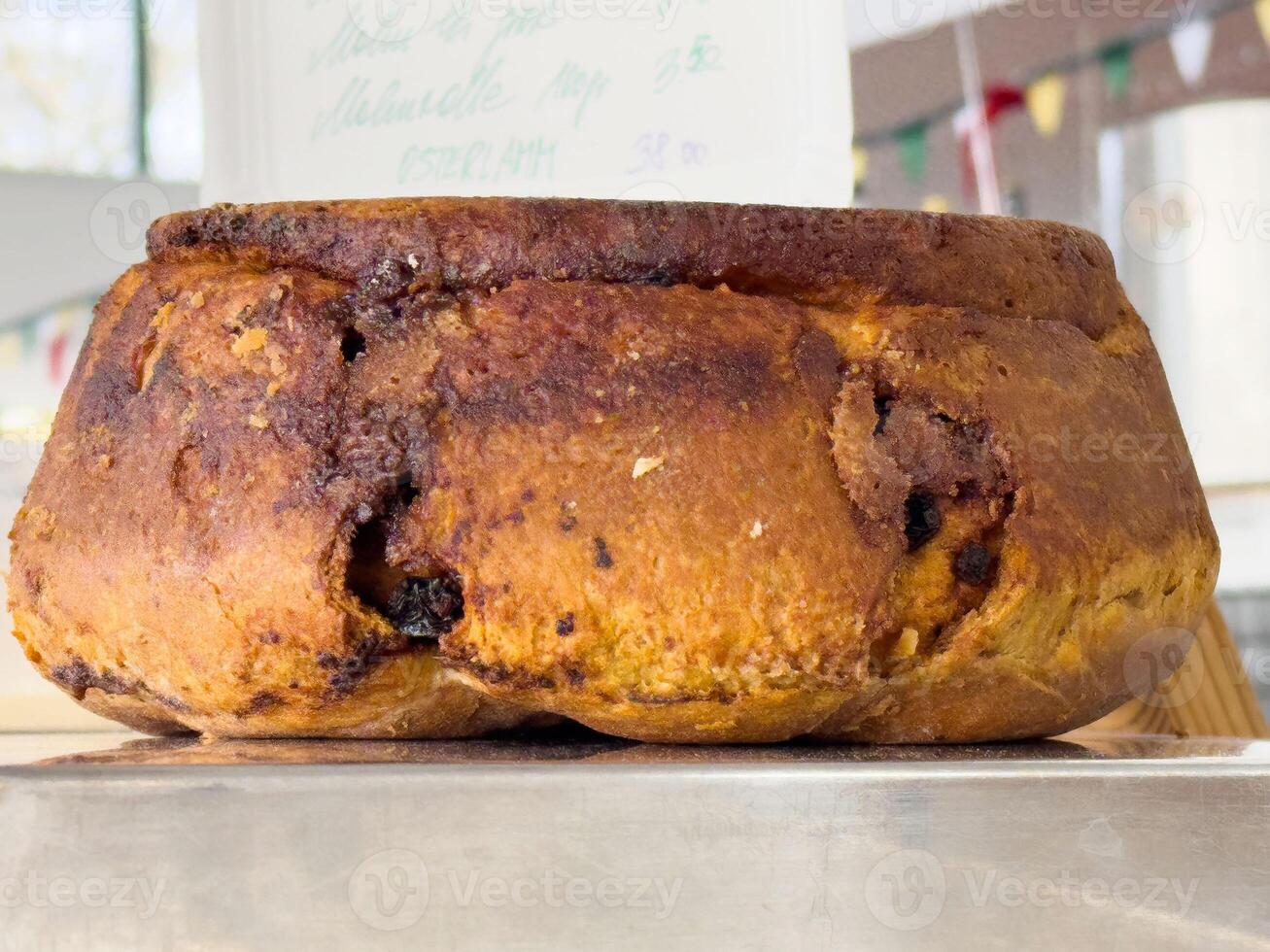 Traditional italian panettone with raisins and currants in bakery display photo