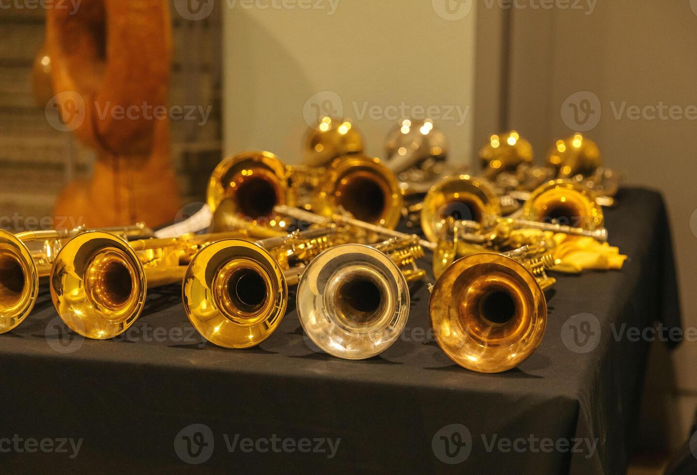 Display of brass musical instruments on black table photo