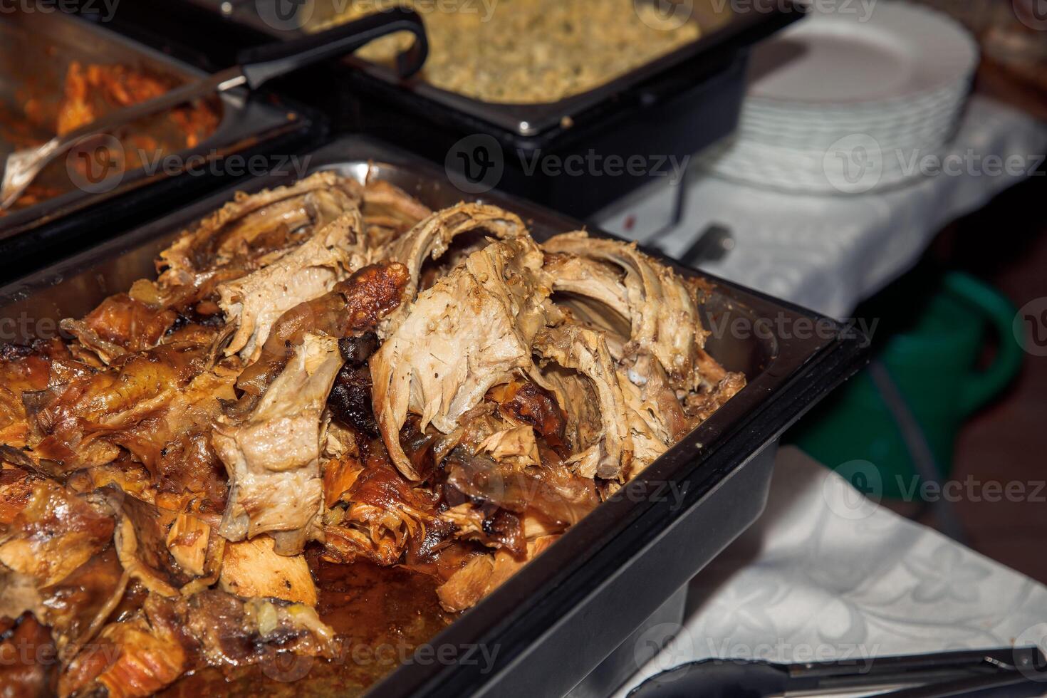 Delicious slow-cooked pork roast in metal tray at buffet table photo