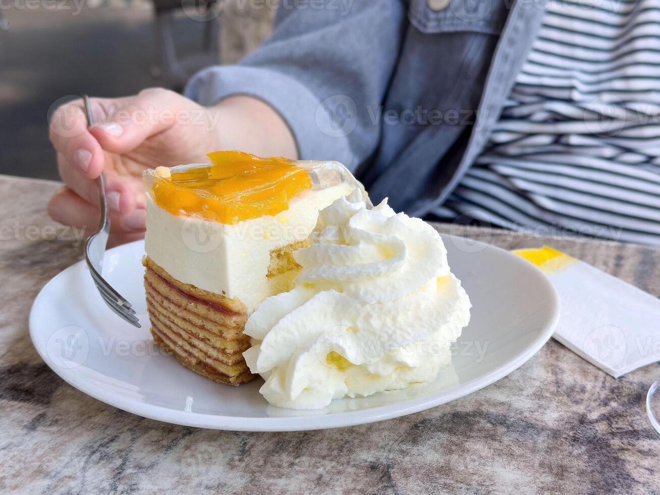 Delicious mango cream cake with whipped topping and layers on a plate photo