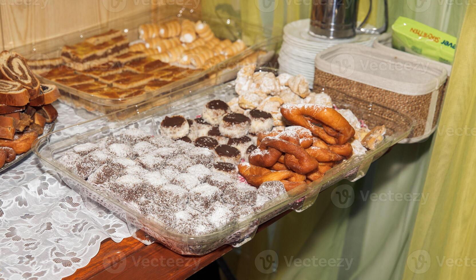 Assorted homemade pastries on tray with powdered sugar and lace tablecloth photo