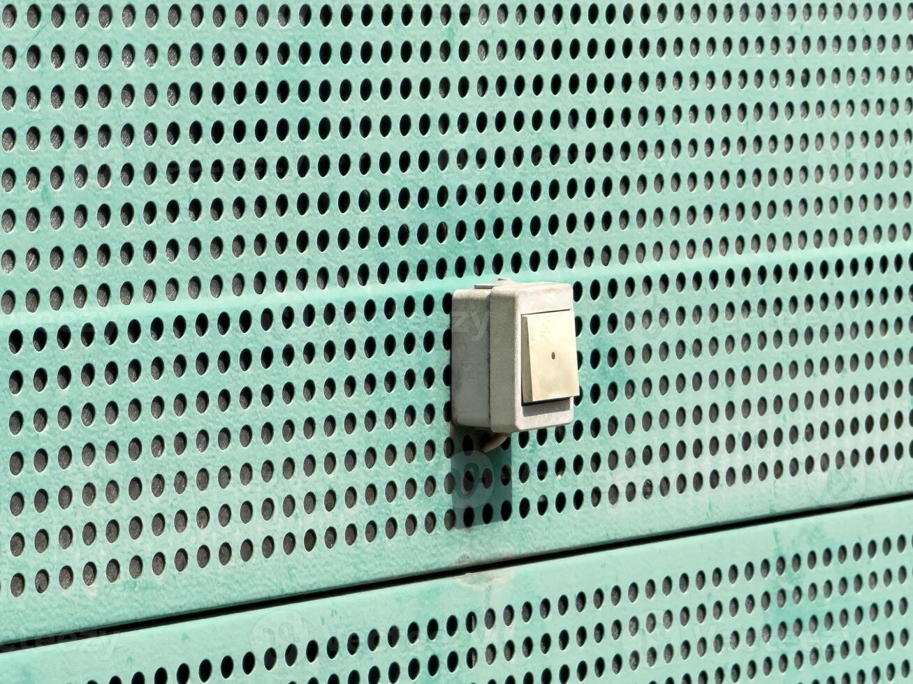 Industrial metal vent with control box on perforated surface photo