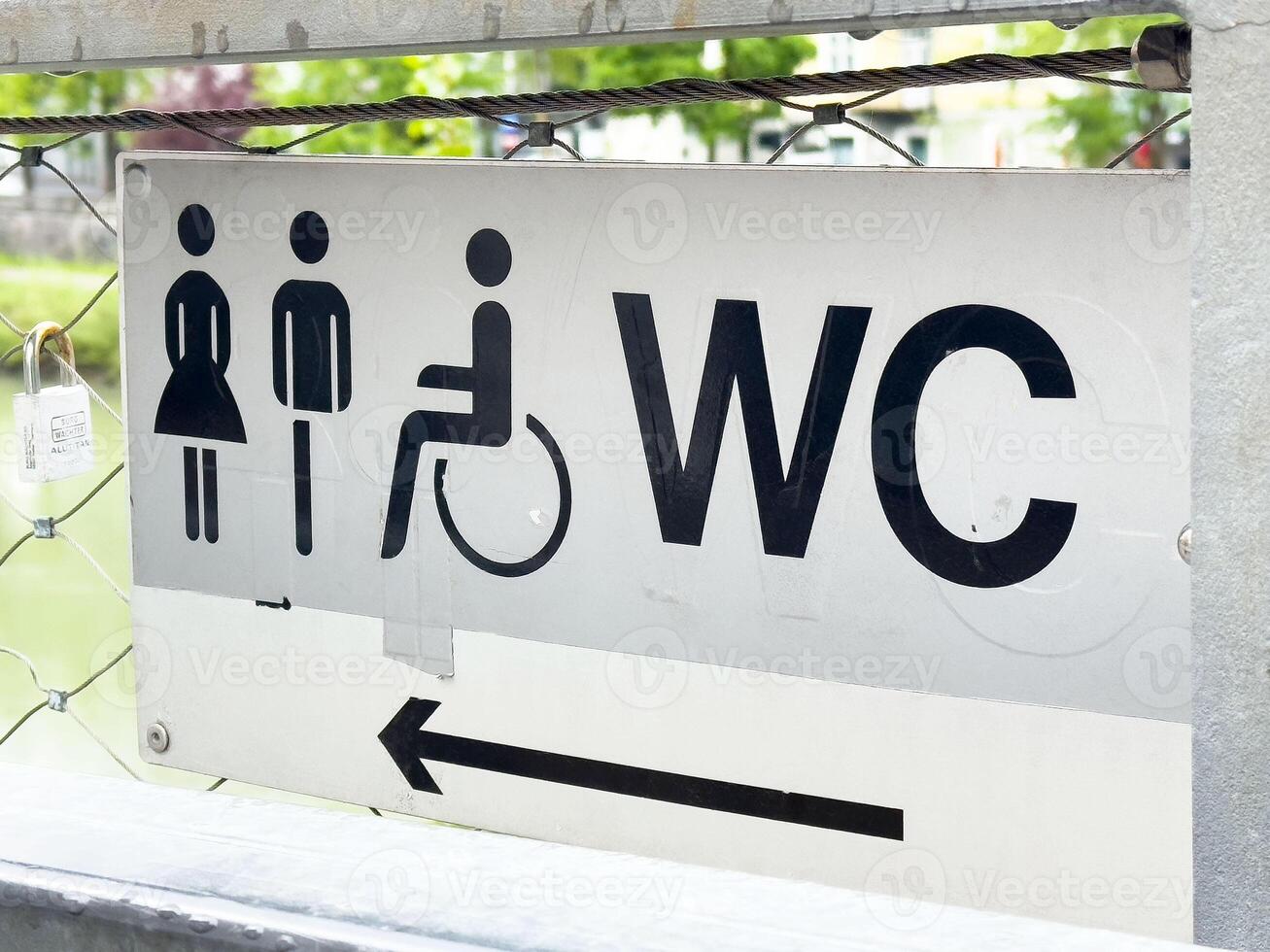 Public restroom sign with symbols for men, women, and wheelchair access photo