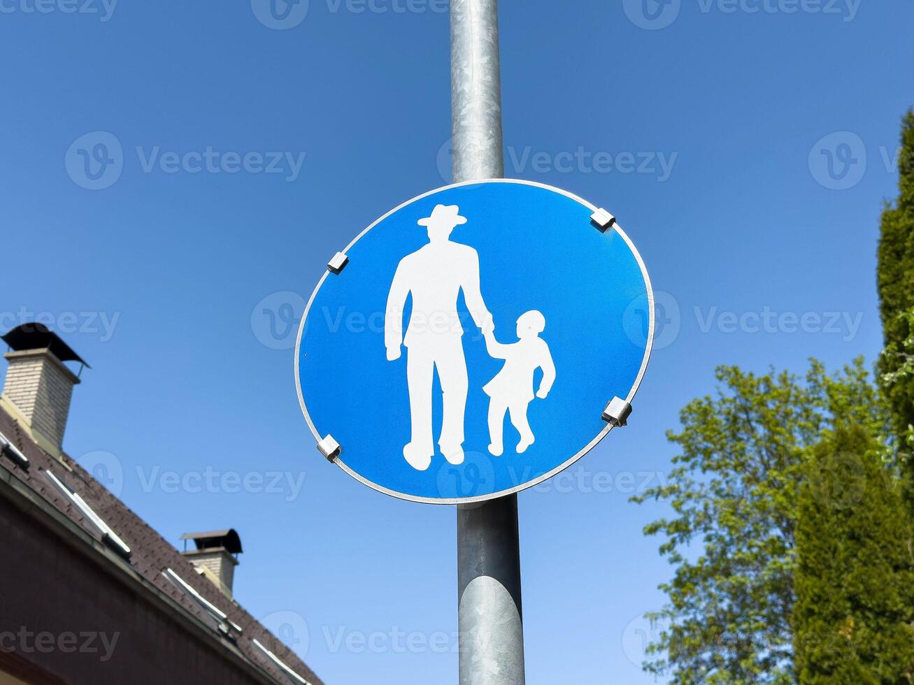 Blue pedestrian sign with silhouette of adult and child holding hands photo