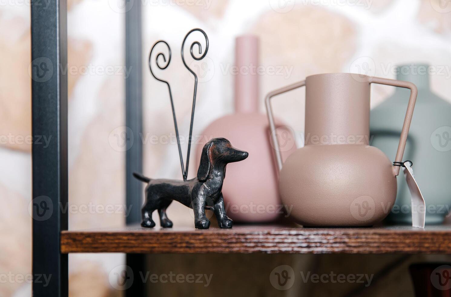 Decorative sculptures and vases on a wooden shelf in modern home interior photo