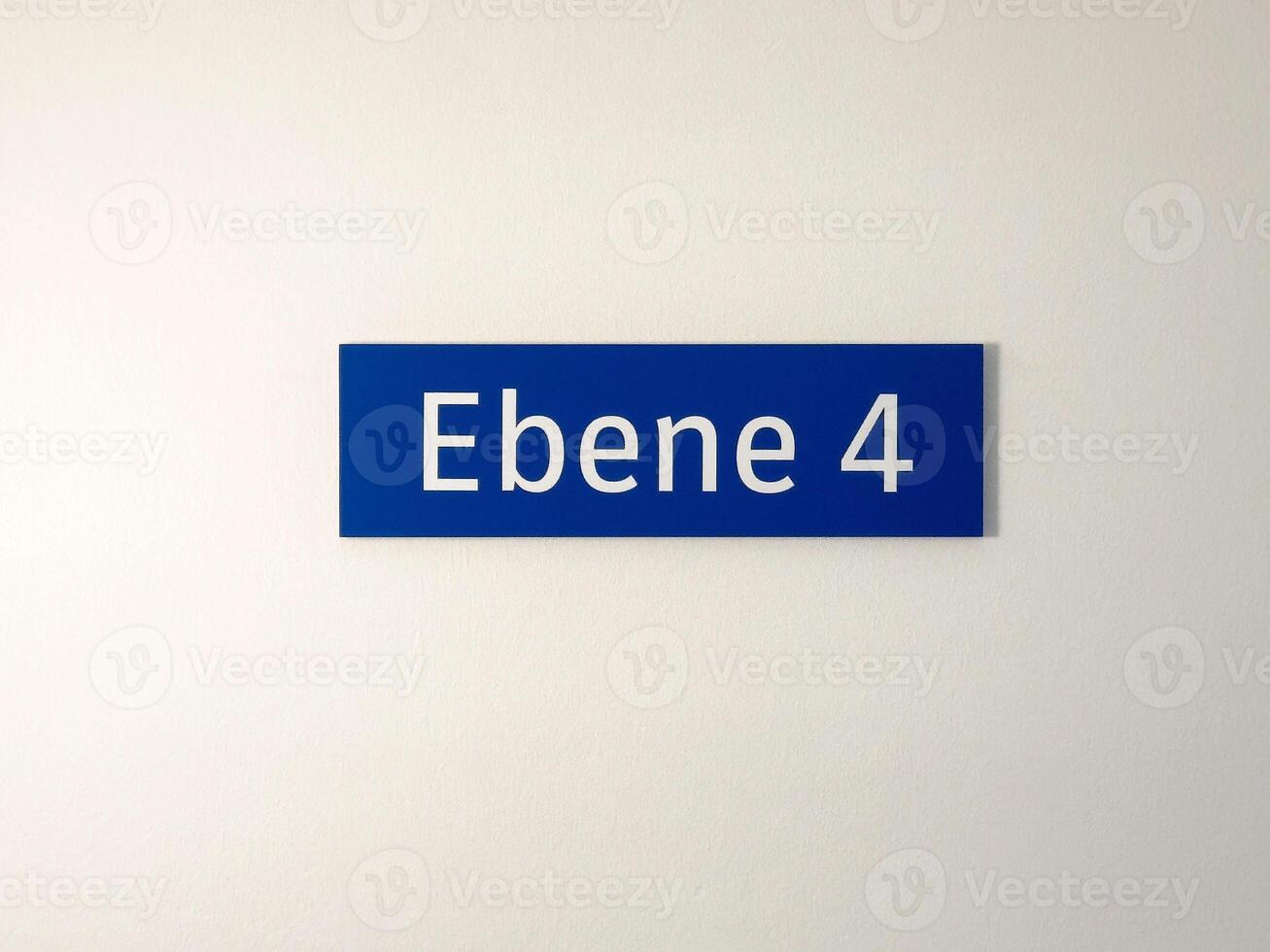 Blue floor sign ebene 4 on white wall indicating level number photo