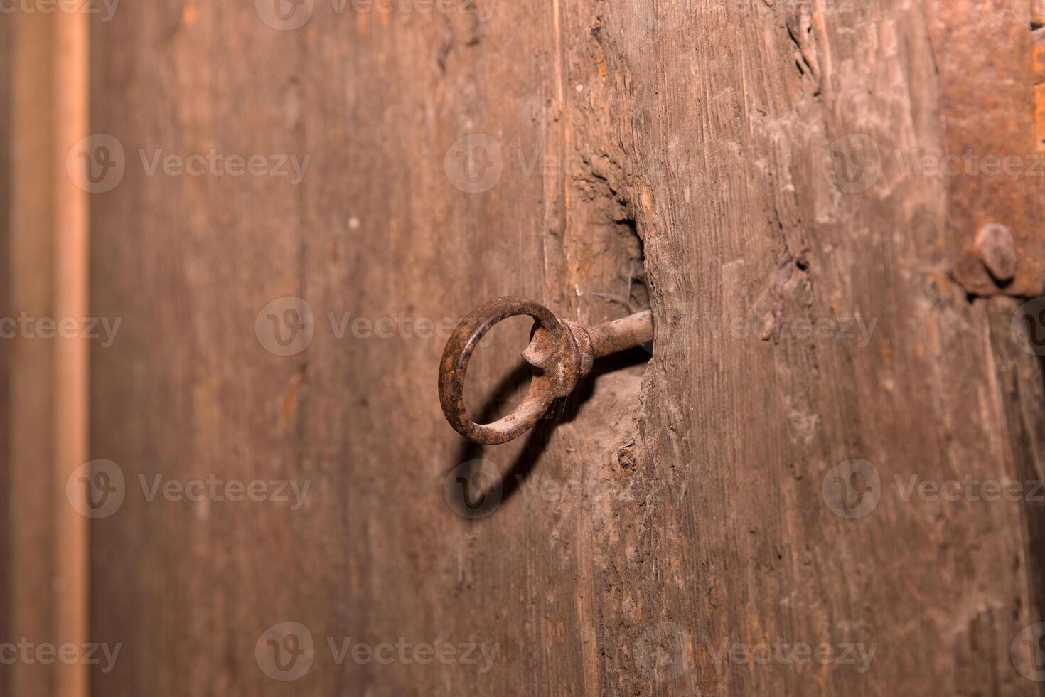 Rustic iron key in antique wooden door lock photo
