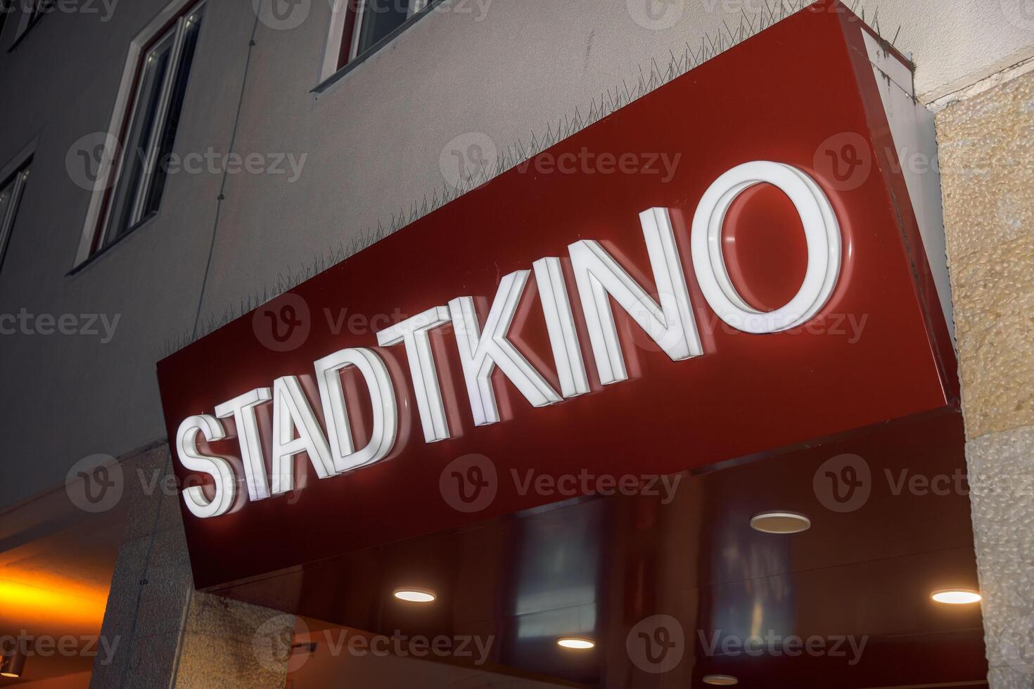Stadtkino theater entrance - red signage in urban setting photo