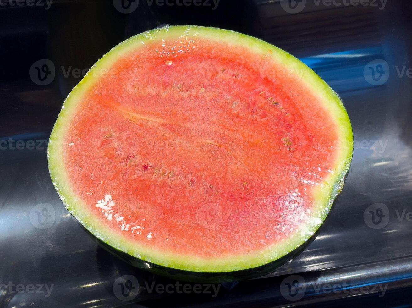 Fresh cut watermelon with juicy red flesh and green rind on display photo