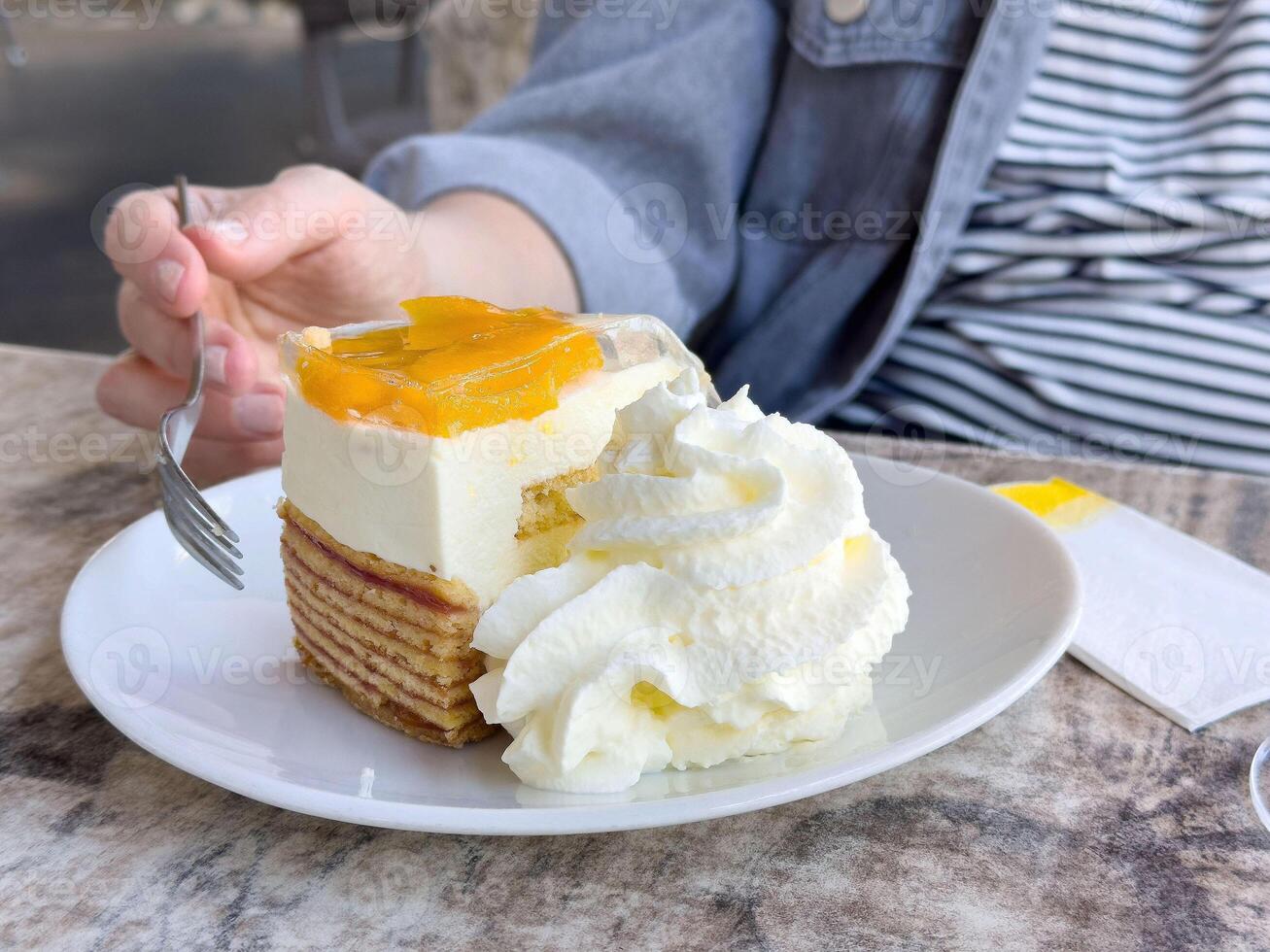 Delicious layered cake with whipped cream and peaches on a plate photo
