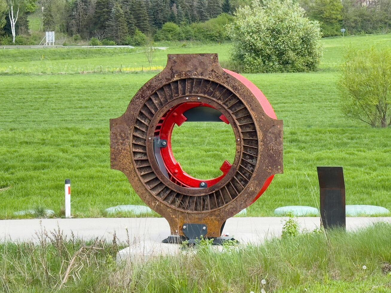 Industrial metal sculpture in green landscape photo