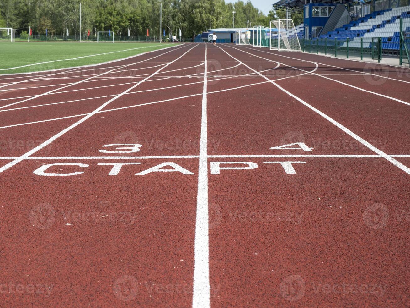A Red treadmill at the stadium with white lines photo