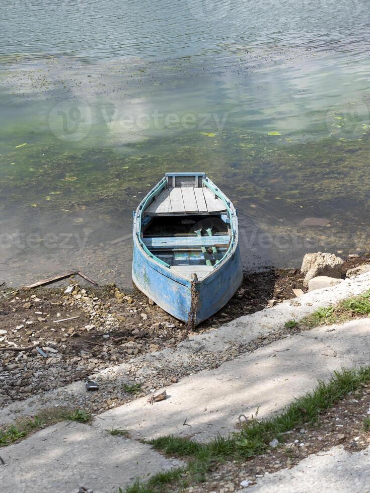 The Small wooden boats of multiple colors moored on the shore of Lake Abrau photo