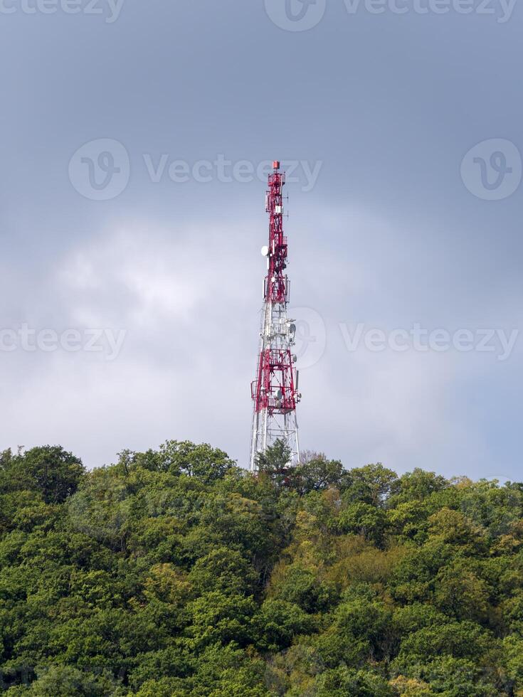 Directional antenna array on a red and white communication tower against sky photo