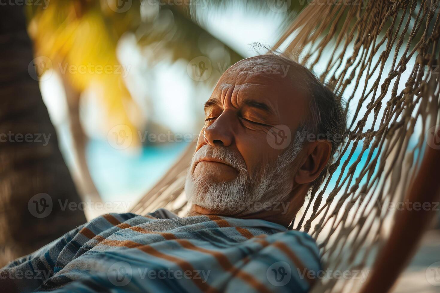 An older man is sleeping in a hammock photo