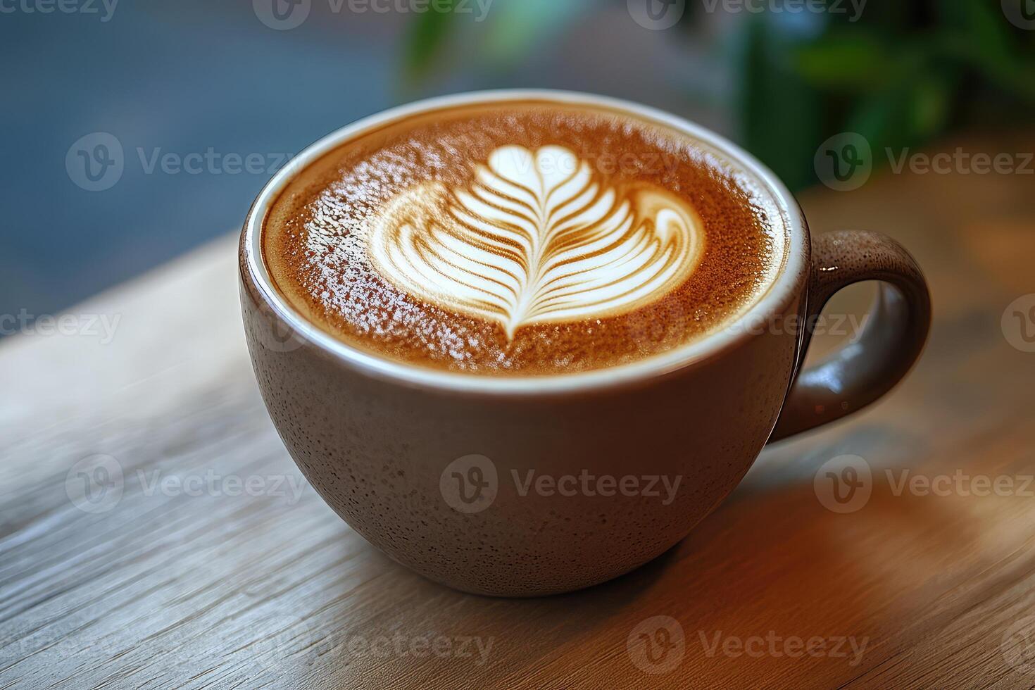 A latte in a brown cup on a wooden table photo