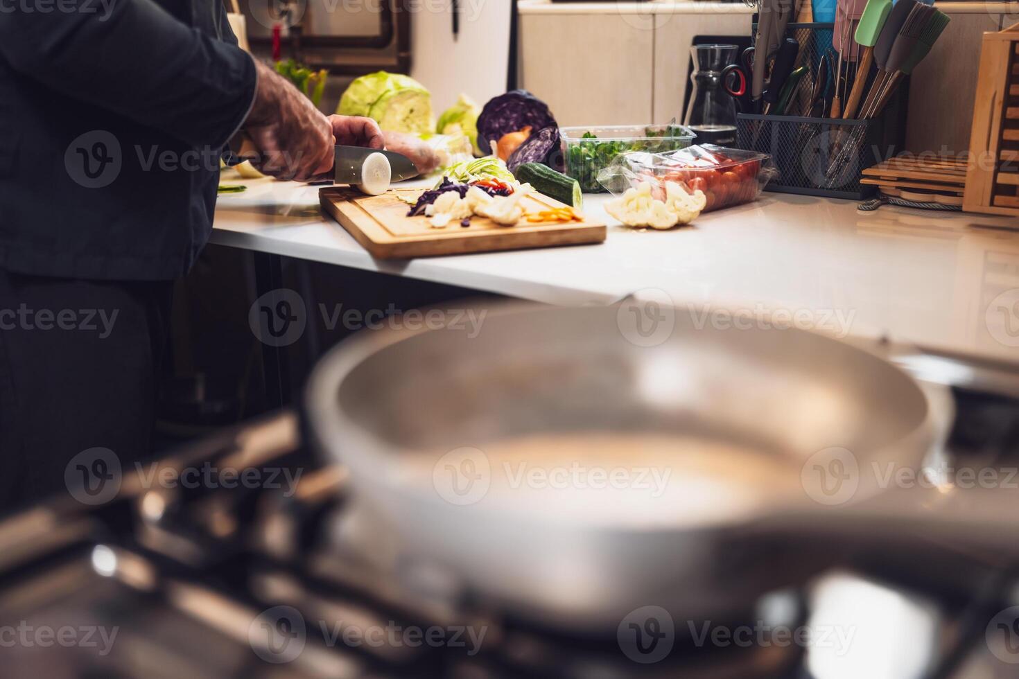 Busy uniformed cook preparing food with precision and care in modern professional kitchen. photo