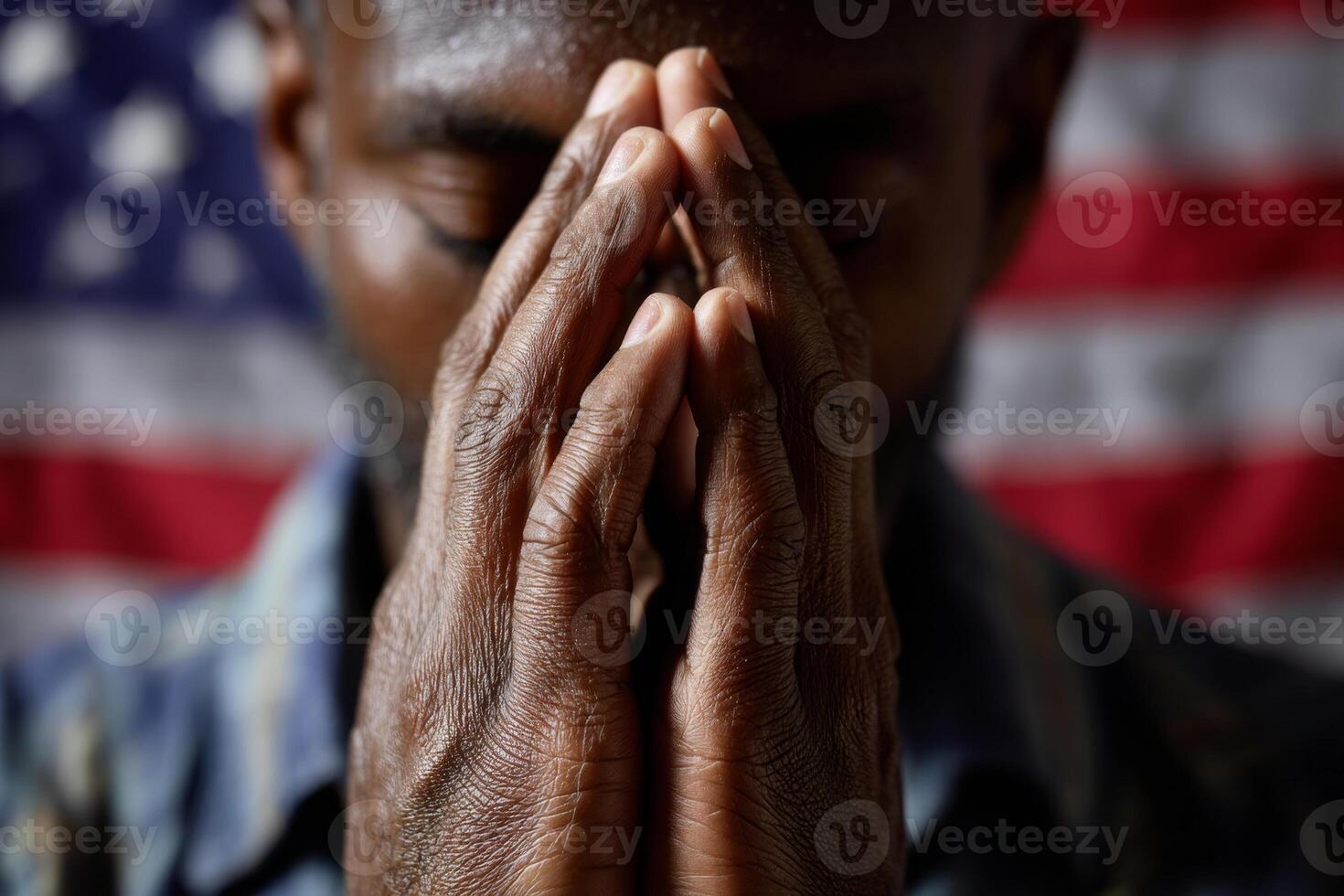 Man praying in front of American national flag photo