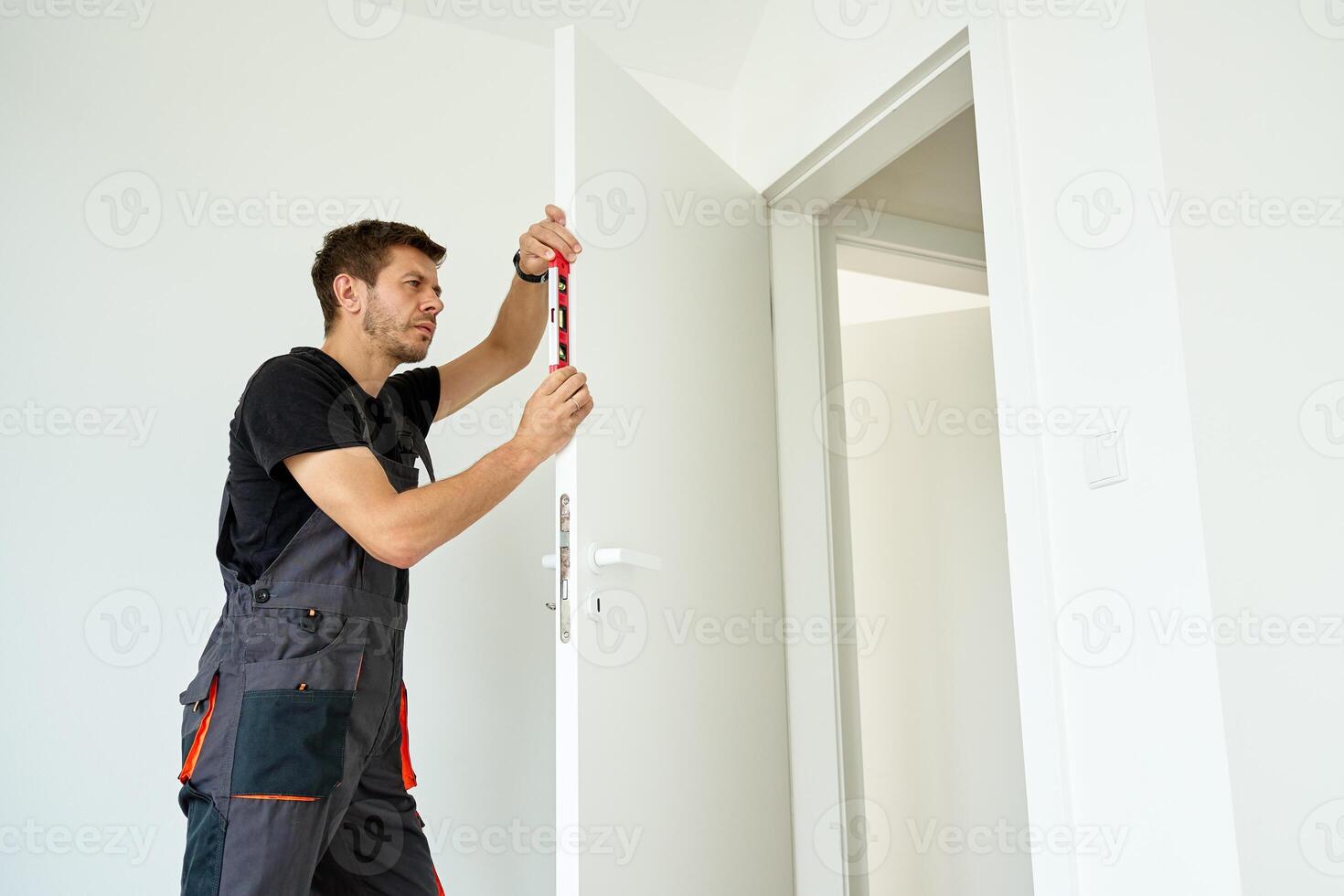 Carpenter Checking Door Alignment with Spirit Level photo